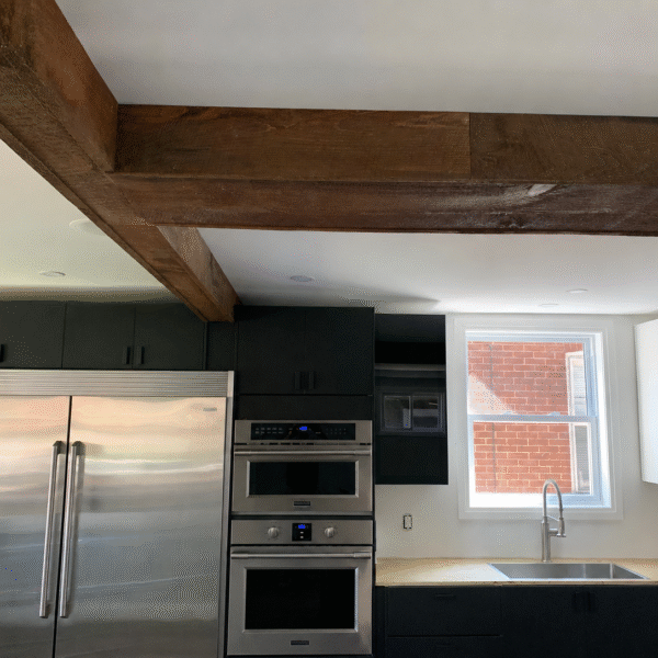 Bold Matte Black Kitchen with Warm Wood Beams